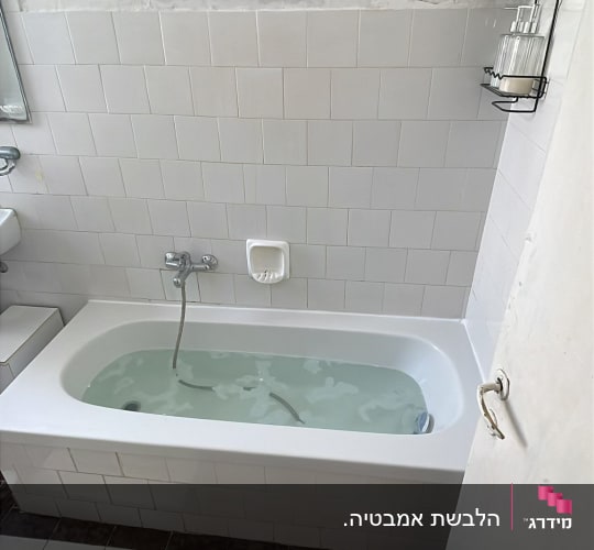 אמבטיה עם אריחים לבנים וברז כסוף